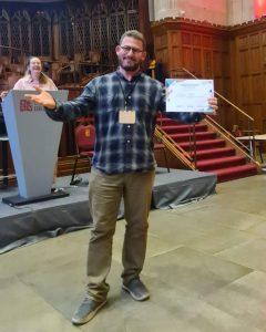 Oussama Metatla poses with an award at the pre-CHI event.